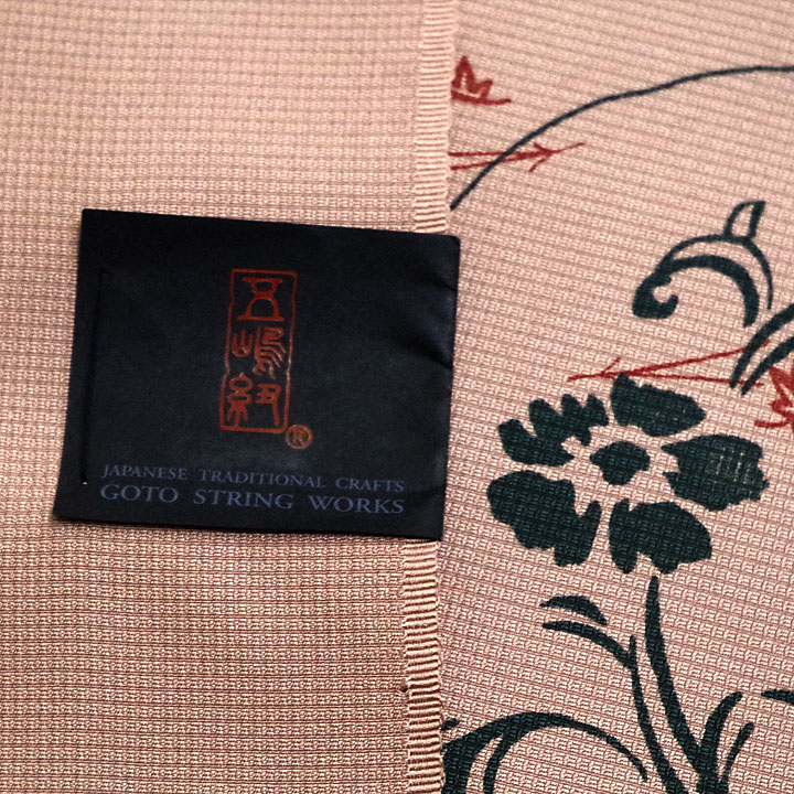 五嶋紐ブランド　染九寸名古屋帯【柿色　流水に舞う花々】